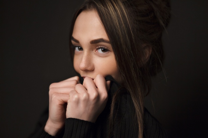 Portrait of a young woman with brown hair wearing a black sweater