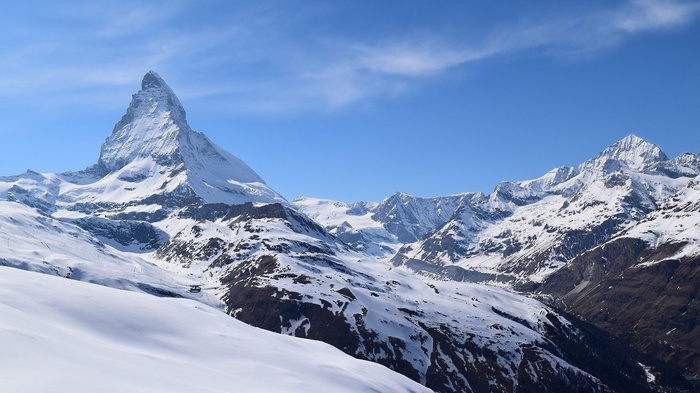 Matterhorn mountain range covered in snow under a blue sky