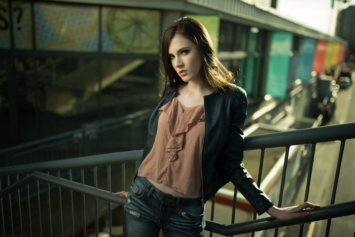 Woman in leather jacket and jeans on stairs
