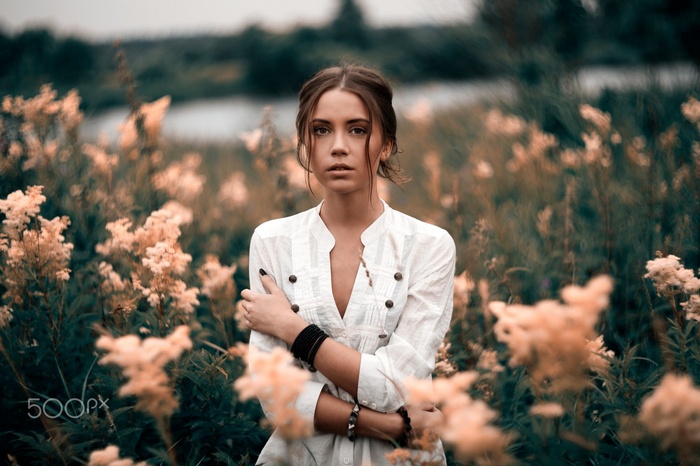 Woman in white shirt standing in a field