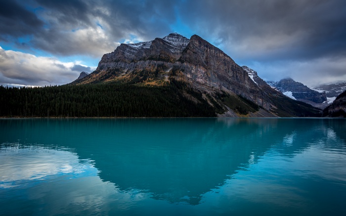 Turquoise lake reflecting mountains and forest