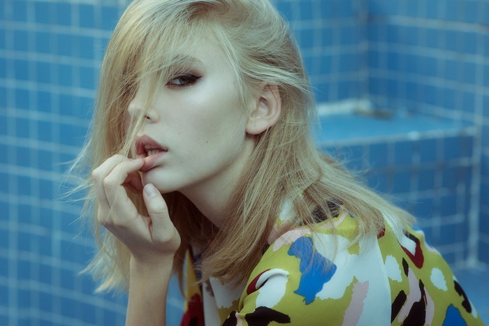 Portrait of a blonde woman with finger on lips