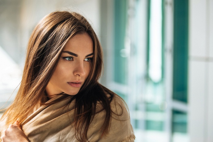 Woman with long brown hair wrapped in a shawl