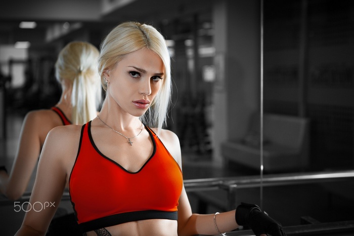 Woman in red sportswear with blonde hair in a gym