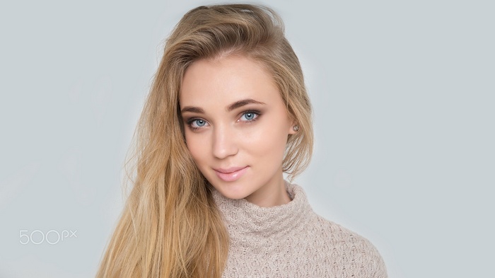 Woman with blonde hair wearing a sweater