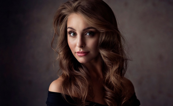 Woman with wavy brown hair and makeup
