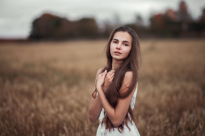 Young woman in a white dress in a field