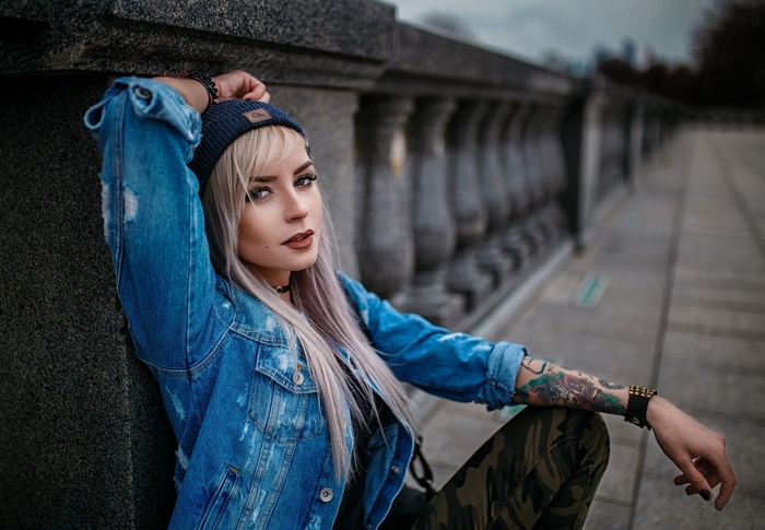 Woman with blonde hair wearing a denim jacket and beanie