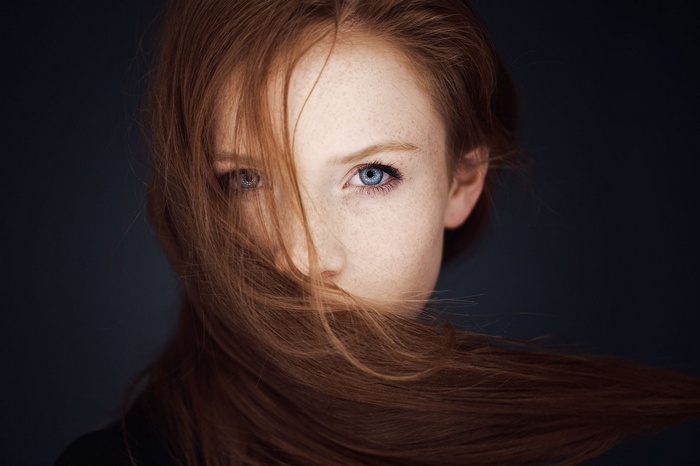 Young redhead woman with blue eyes and freckles