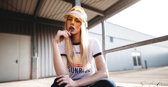Woman with blonde hair wearing a T-shirt and visor