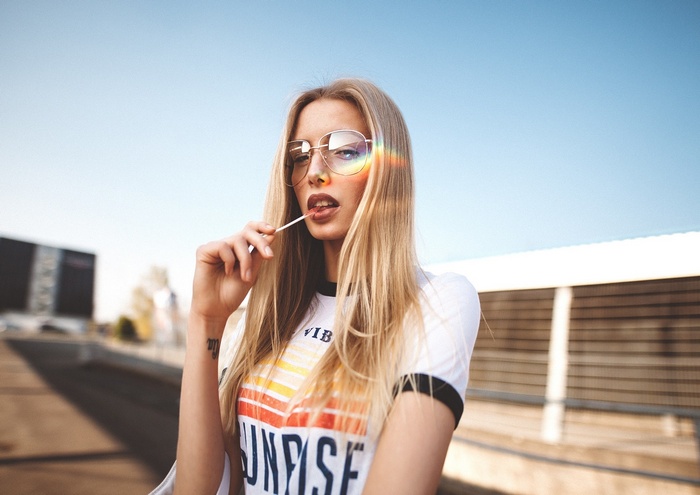 Woman with lollipop wearing sunglasses and t-shirt