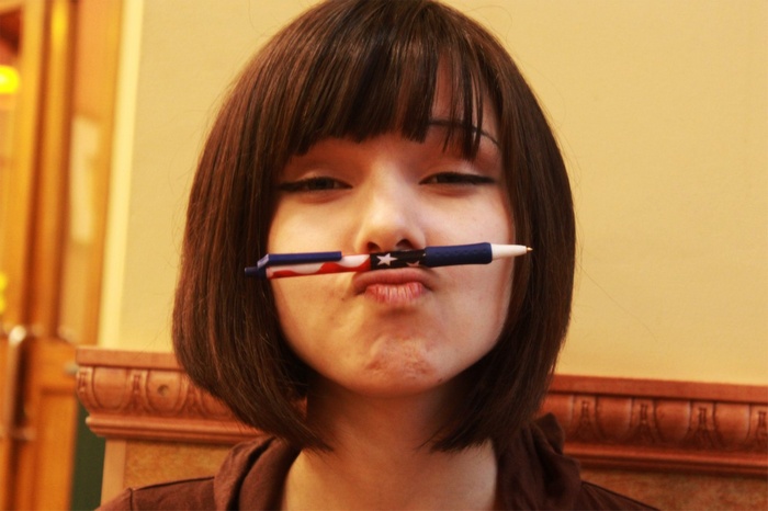 Woman with a pen under her nose