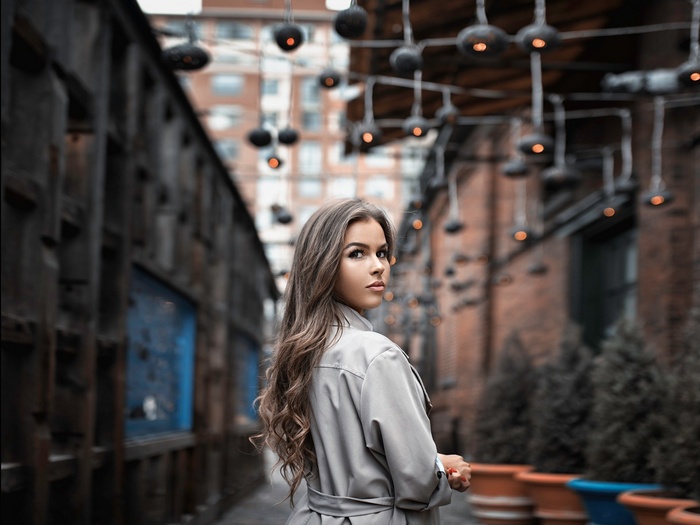 Woman in trench coat looking over shoulder