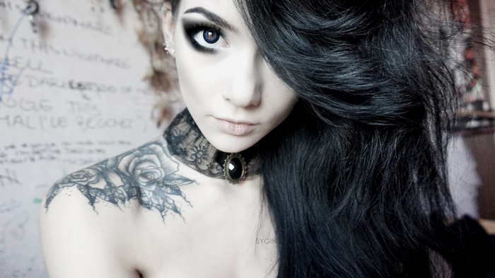 Model with dark hair and tattoos