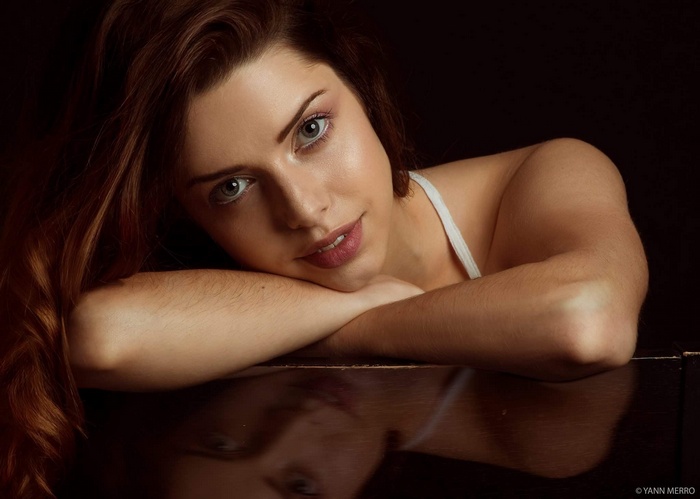 Woman with long brown hair resting her arms