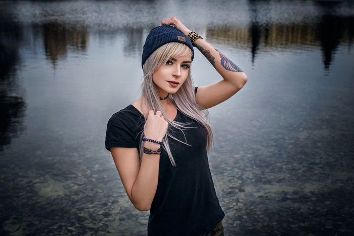 Woman with tattoos and beanie by the water