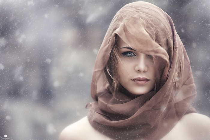 Woman with blonde hair wearing a brown headscarf in snow
