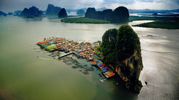 Floating village on the water with limestone karsts