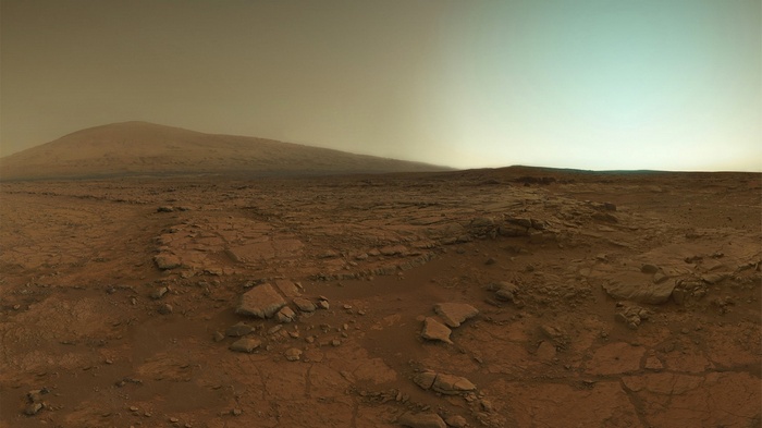 Mars landscape with distant mountain and hazy sky