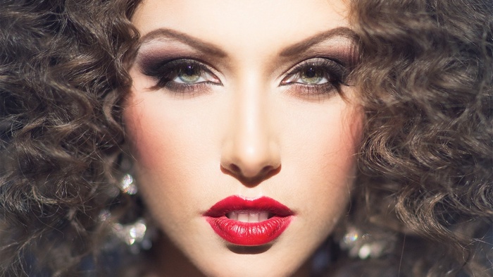 Woman with curly hair and red lipstick makeup
