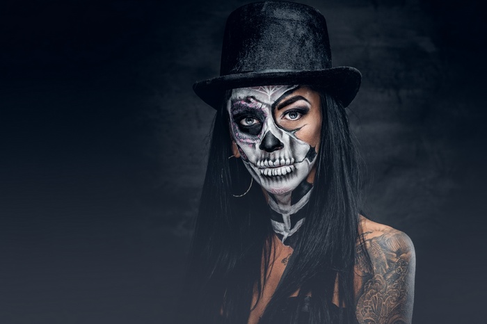 Woman with skull makeup and top hat