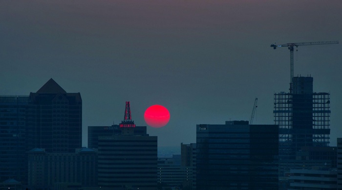 Cityscape with red sun at dusk