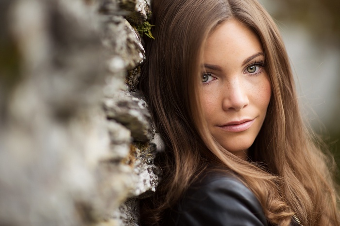 Woman leaning against a stone wall