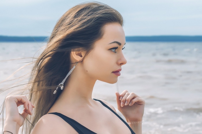 Woman with long brown hair in profile at the beach