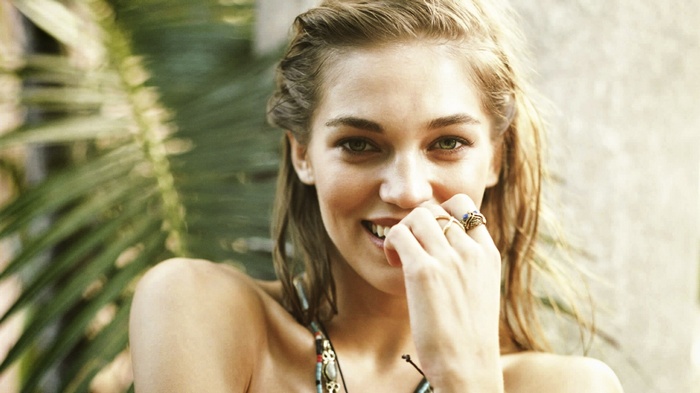 Woman with hand covering mouth and wearing rings