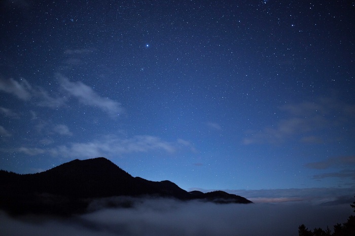 Night sky over mountains with mist and stars