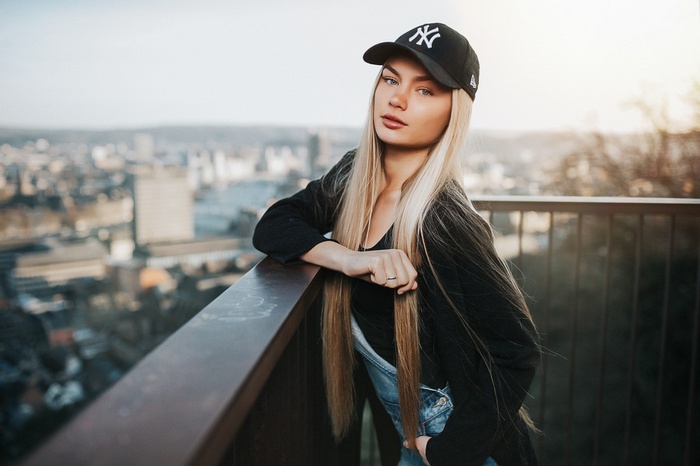 Woman wearing a New York Yankees baseball cap and overalls