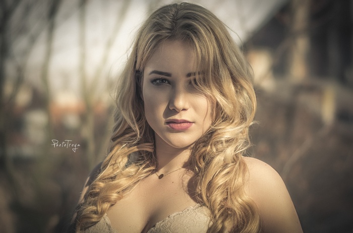 Woman with blonde hair in a bra outdoors