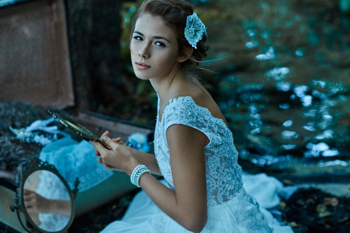 Woman in white dress holding a mirror