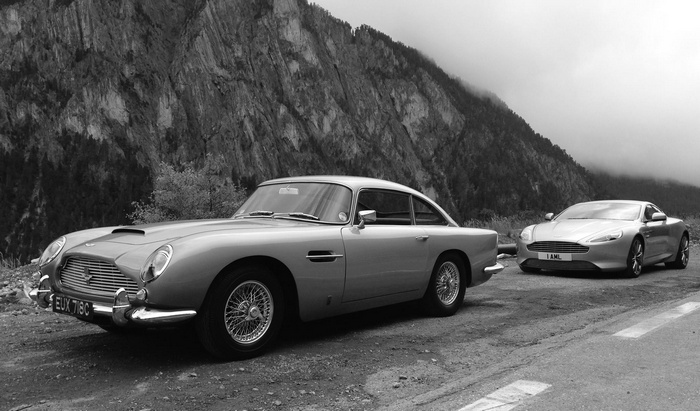 Aston Martin DB5 and DB9 parked by mountains