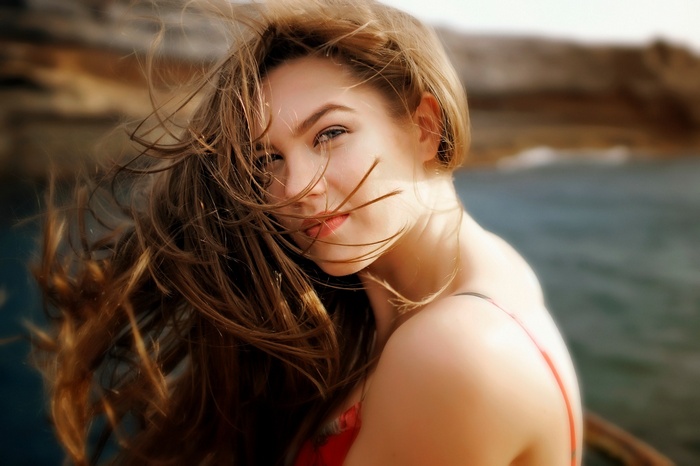 Woman with windblown hair by the sea