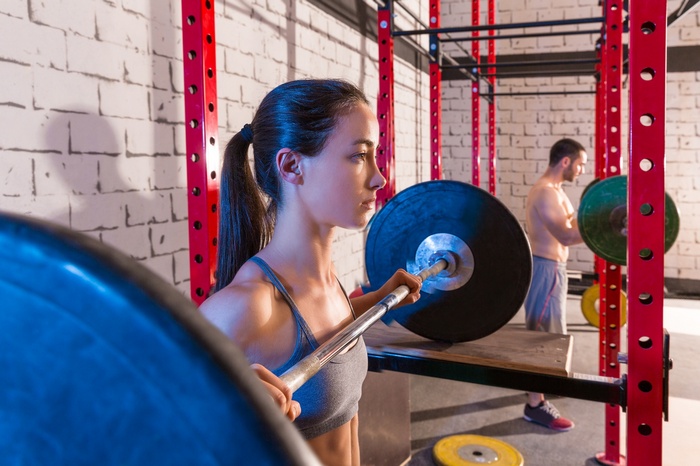 Woman and man weightlifting in a gym