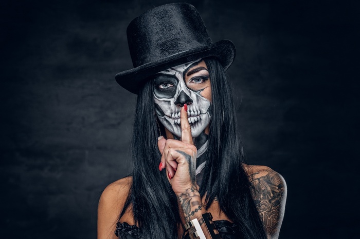 Woman with skull makeup and top hat
