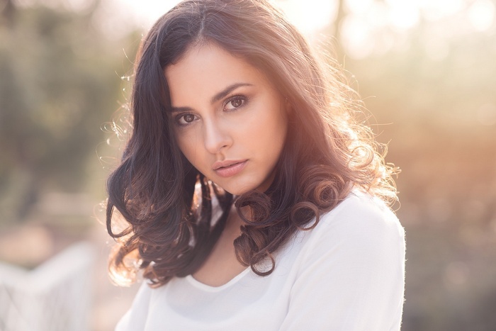 Woman with dark wavy hair outdoors