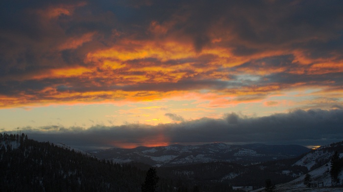 Sunset over snow-covered mountains and forests