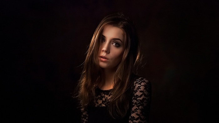 Woman with auburn hair in a black lace top