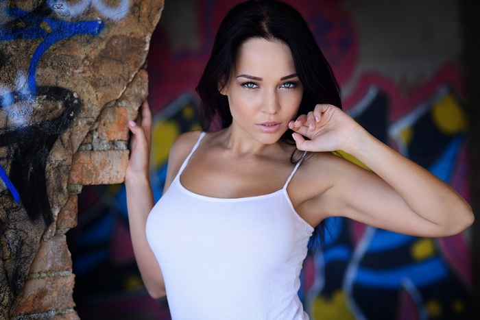 Angelina Petrova in white tank top with graffiti wall