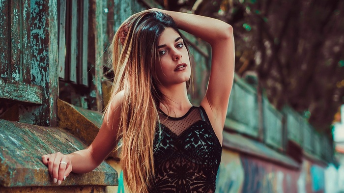Woman in black see-through top posing outdoors