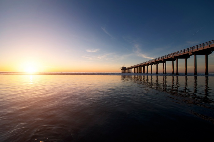 Sunset over the ocean with a pier