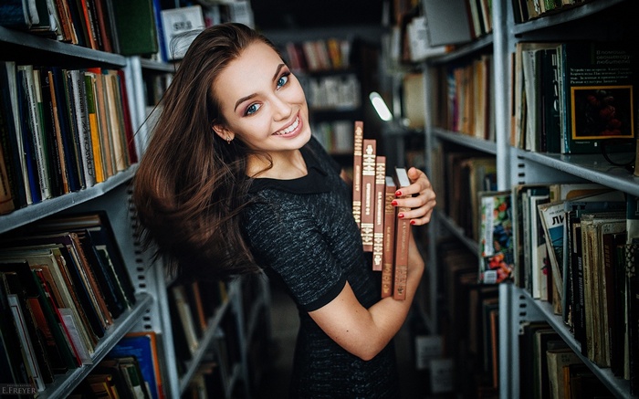 Woman holding books in a library