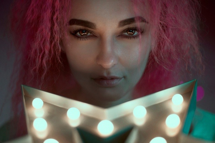 Woman with pink hair holding a star light