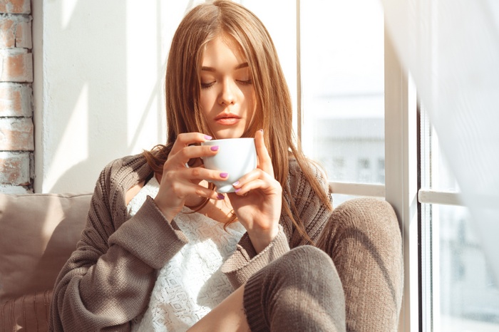 Woman drinking from a mug indoors