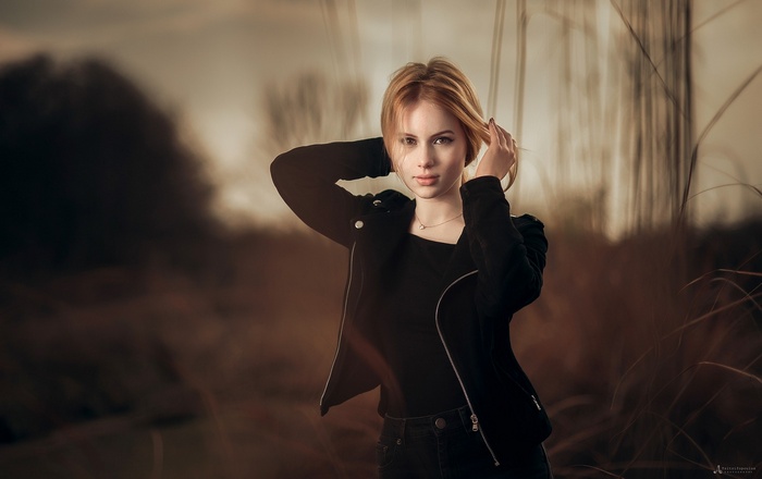 Woman with blonde hair wearing a black jacket