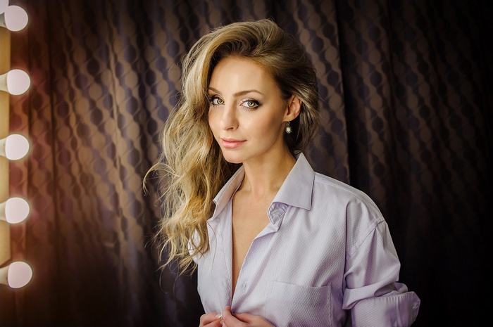 Woman with blonde hair wearing a light purple shirt