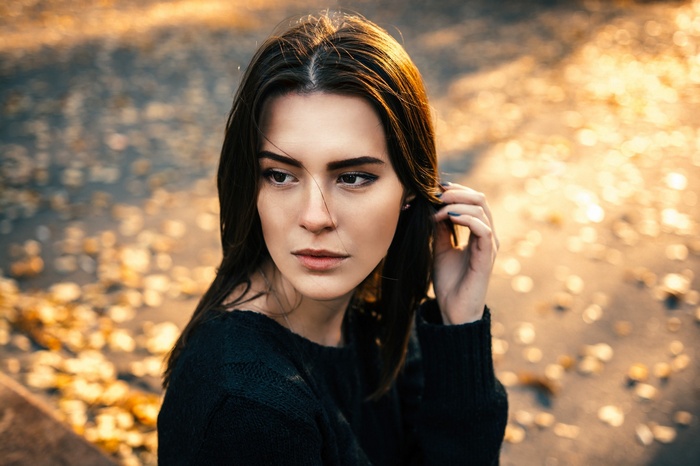 Woman in black sweater with autumn leaves