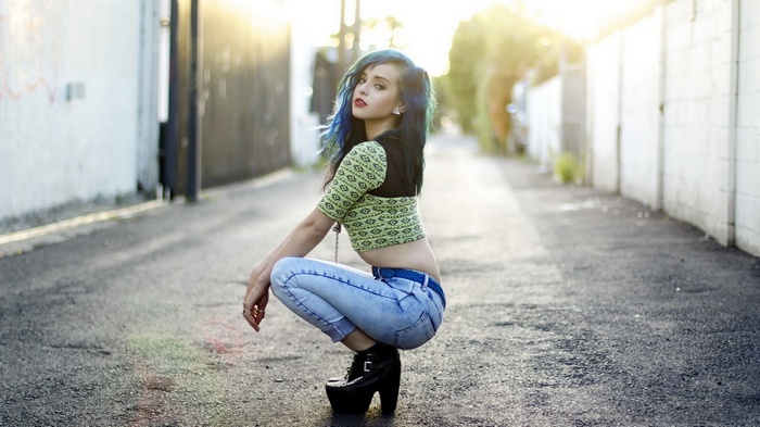 Woman with blue hair wearing high heels and jeans